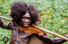 a man with a large afro is holding a wooden stick over his shoulder