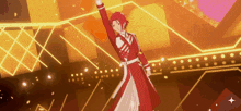 a person in a red coat is standing on a stage with their arm in the air .