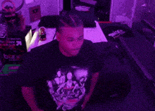 a man in a purple shirt is sitting in a room