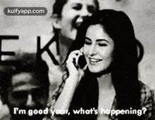 a woman is talking on a cell phone while another woman laughs behind her .