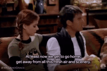 a man and a woman are sitting on a couch and the man says at least now we get to go home