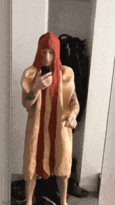 a man in a hot dog costume is taking a picture of himself in the mirror .