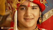 a close up of a man wearing a red turban with sony television written on the bottom