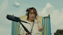 a young man wearing headphones and holding a microphone in a playground