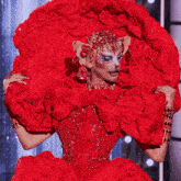 a woman is wearing a red dress with ruffles and rhinestones on it