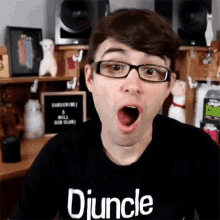 a man wearing glasses and a shirt that says djuncle is making a surprised face