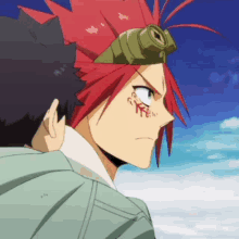 a man with red hair and a goggles on his head stands next to another man .