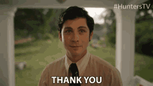 a man in a striped shirt and tie is giving a thank you gesture