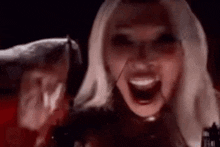 a woman is holding a knife in her hand and screaming .