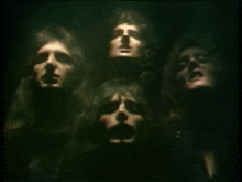 a group of men are standing in a dark room with their heads visible