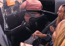 a woman in a pink shirt sits in a chair with a sign that says zulu