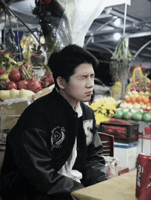 a young man wearing a black jacket with the letter s on it