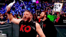 a wrestler wearing a black tank top with ko on it