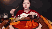 a woman is sitting at a table eating a variety of foods