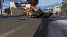a tank is driving down a street in front of a building that is burning