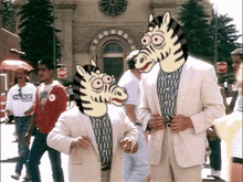 a man wearing a guess shirt stands next to a man wearing a zebra head