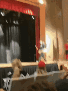a blurry image of a stage with a red curtain