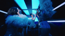 a group of women are dancing in a dark room