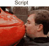 a man is kissing the side of a red car with the word script above him