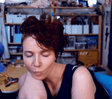 a woman with her eyes closed is sitting in front of a shelf that has the number n7 on it