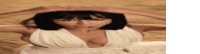 a woman in a white dress is laying in the sand with her arms outstretched