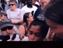 a man wearing a hat that says ' pat ' on it stands in a crowd of people