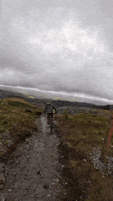 a person is riding a bike down a dirt road