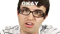 a man wearing glasses is making a face and the word okay is above him