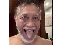 a man with a beard is sticking out his tongue