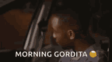a man is sitting in a car with the words morning gordita above him