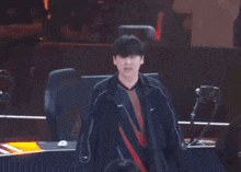 a man wearing a nike jacket stands in front of a computer