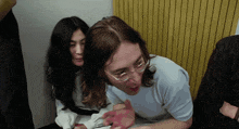 a man and a woman are sitting next to each other and the woman is wearing glasses