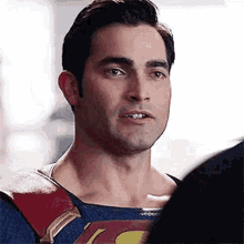a man in a superman costume is standing next to another man .