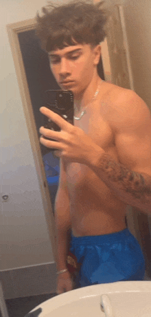 a shirtless man taking a picture of himself in a mirror