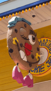 a statue of a cookie wearing pink shoes and a hat stands in front of a martini cookie sign