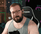 a man with a beard wearing glasses and a tracing chair