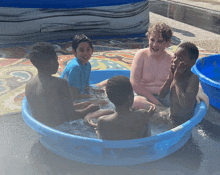 a group of young boys are sitting in a blue pool