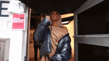 a woman holding an umbrella in front of a sign that says you are not permitted to enter set up