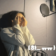 a woman covering her face with her hands in front of a microphone with a caption that says tt
