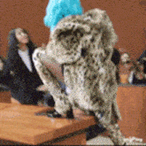 a woman in a leopard print coat stands on a table