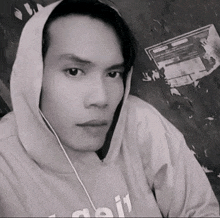 a black and white photo of a man wearing a hooded sweatshirt that says ' aoi ' on it