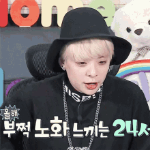 a young man wearing a black hat and a necklace with the number 24 written on it