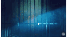 a man is behind bars in a dark room with a blue light behind him