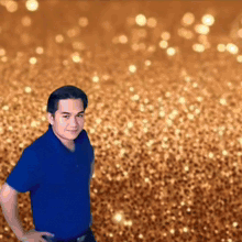 a man in a blue shirt stands with his hands on his hips