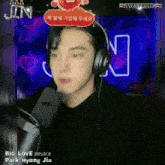 a man wearing headphones and a sign that says jin