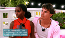 a man and a woman are sitting next to each other and the woman is holding a glass and the man is wearing a pink jacket