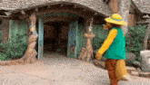 a fox mascot is standing in front of a wooden building with a sign that says restrooms on it