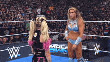 two women are in a wrestling ring with a sign that says mack sww