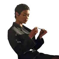 a woman in a black jacket holds a pen in her hand