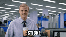 a man in a striped shirt and tie is holding a cup with a straw and the words stick written on it
